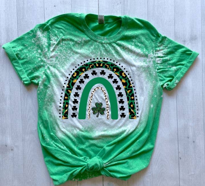 Green t-shirt with a rainbow and shamrock design on a light wooden surface