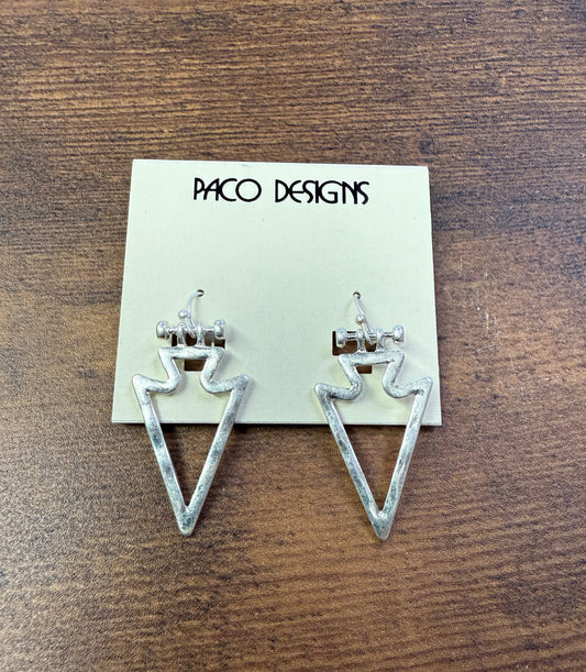 Silver triangle-shaped earrings on a 'Paco Designs' card against a wooden background