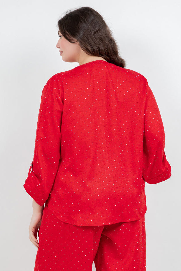 Woman wearing a red with sparkle rhinestones throughout the outfit with a white background