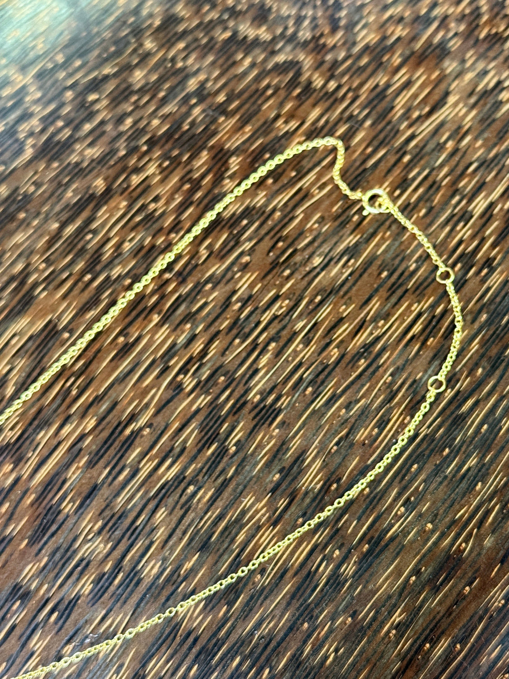 Gold necklace on a wooden surface