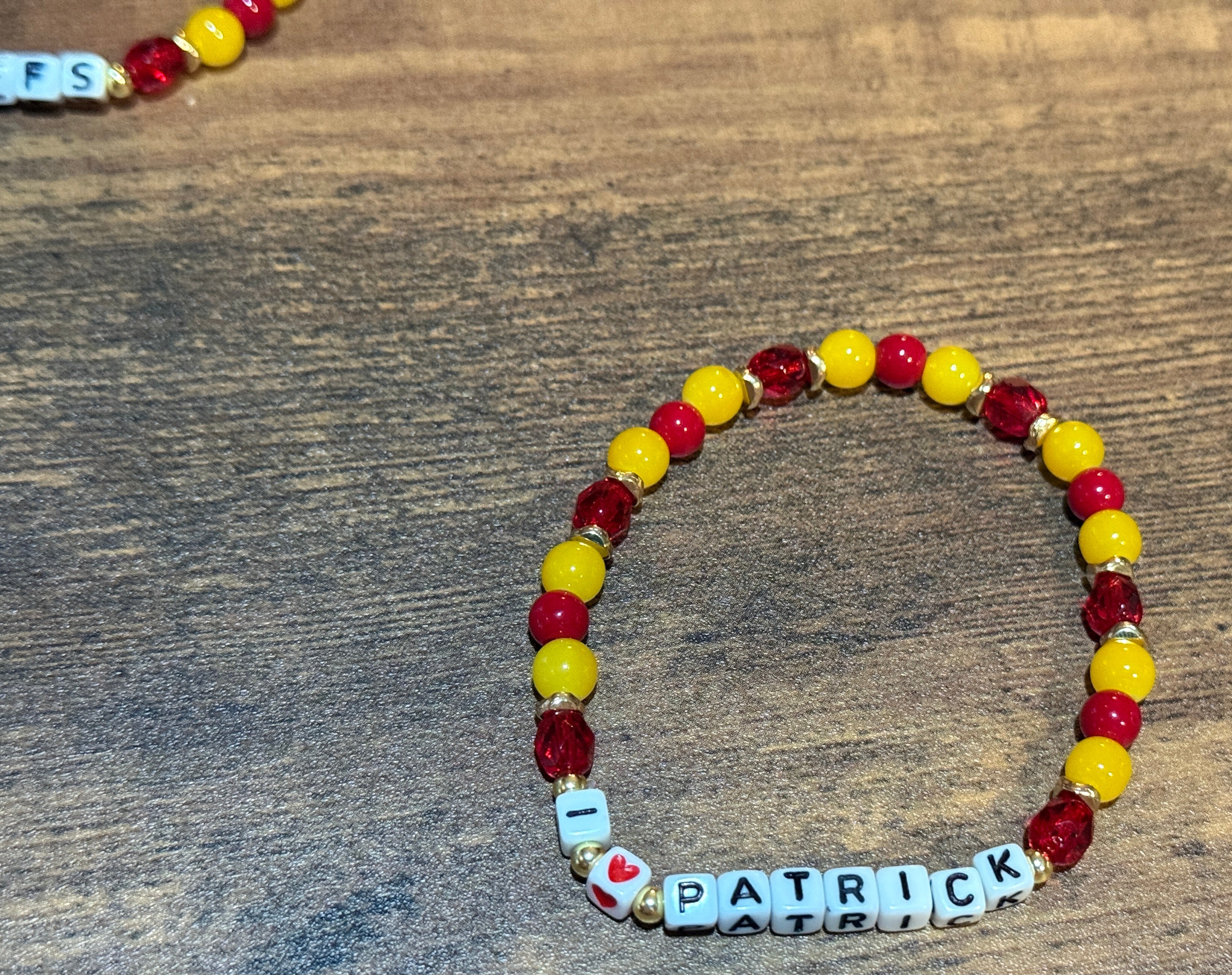 Beaded bracelet with 'Patrick' on a wooden surface