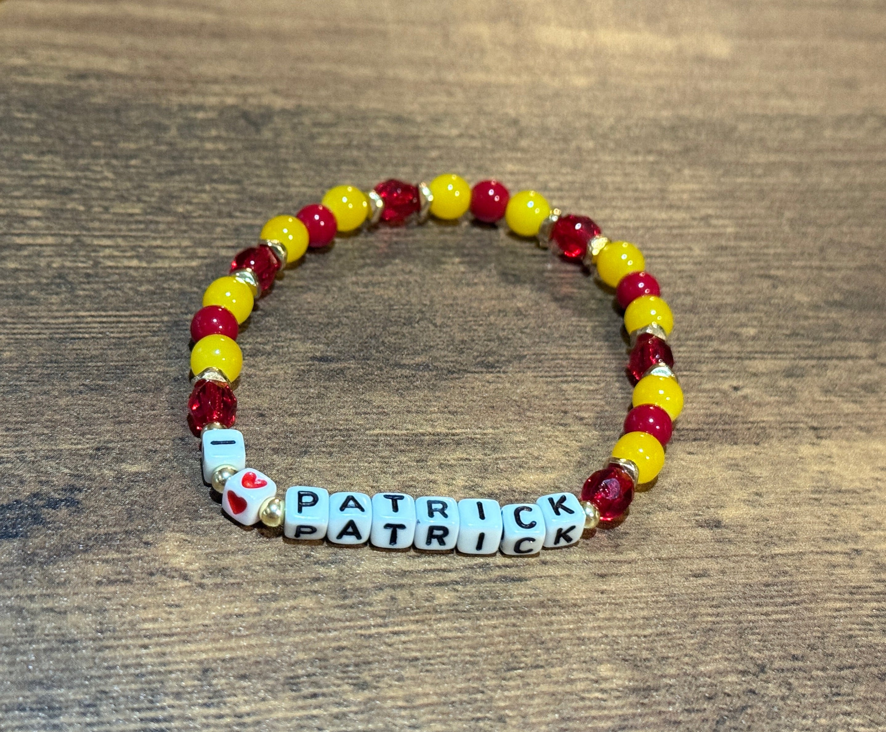 Beaded bracelet with 'Patrick' on a wooden surface