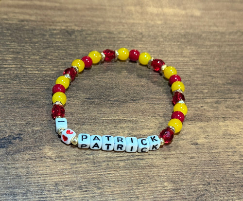 Beaded bracelet with 'Patrick' on a wooden surface