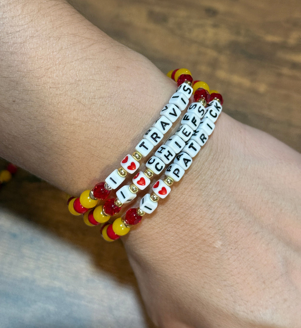 Bracelet with letter beads on a wrist against a wooden background