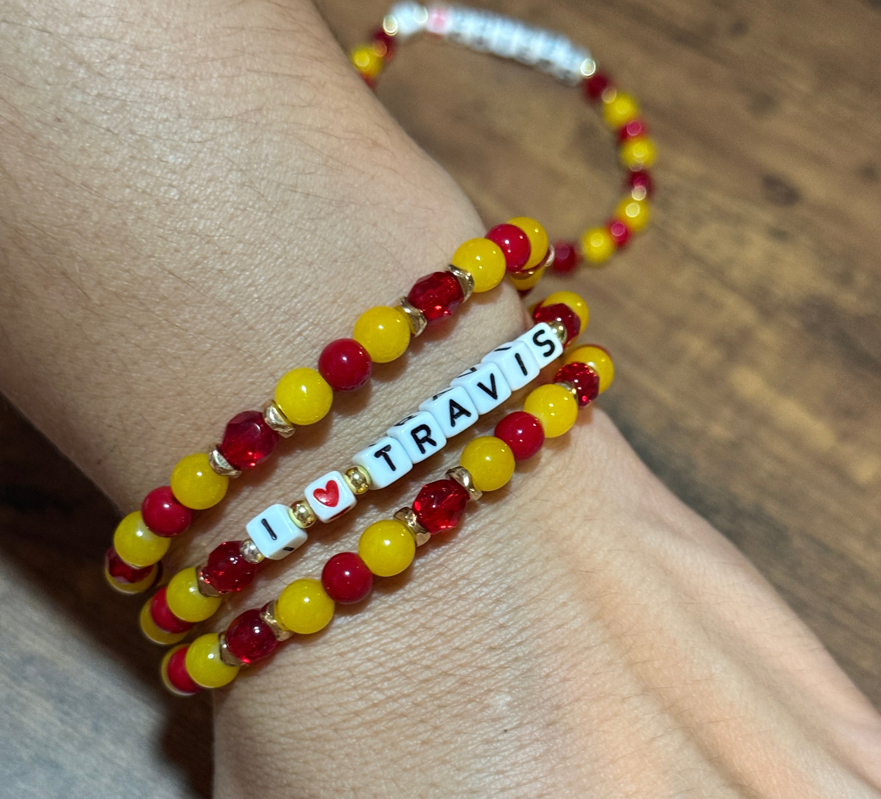 Beaded bracelet with 'SIAM' on a wrist against a wooden background